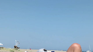 She masturbates her on the naturist beach in public with a voyeur who passes by