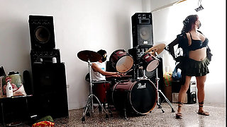 They play the drums for her - she dances, stripping and showing her ass
