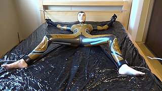 Latex Danielle is attached to the bed and masturbated with the massage vibrator