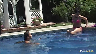 Bored sunbathing lesbian friends are messing with their privates in the outdoor pool